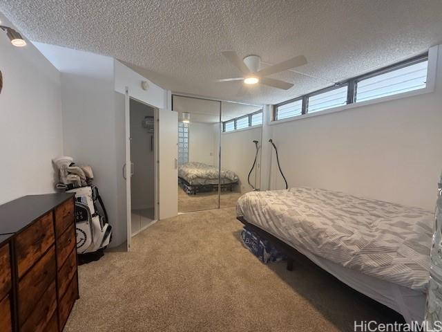 1630 Liholiho St Unit 2001, Honolulu, HI 96822 - bedroom with a textured ceiling, carpet flooring, a closet, and ceiling fan