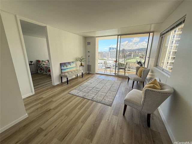 400 Hobron Ln Unit 2114, Honolulu, HI 96815 - sitting room with wood finished floors, baseboards, a view of city, and a wall of windows