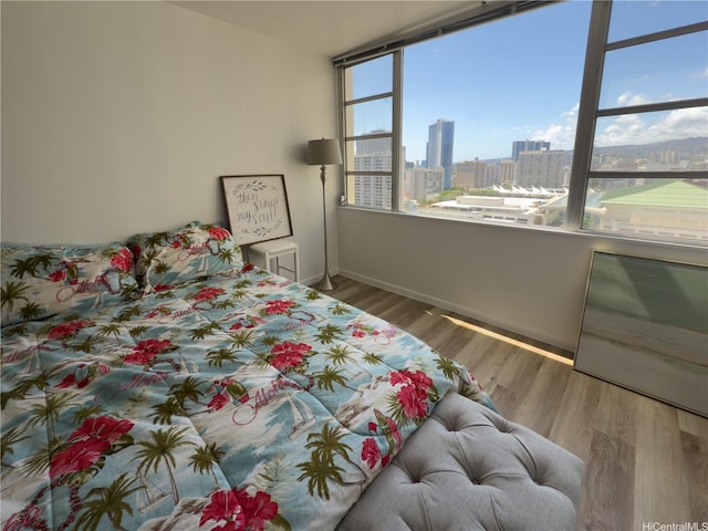 400 Hobron Ln Unit 2114, Honolulu, HI 96815 - bedroom featuring a city view, baseboards, and wood finished floors
