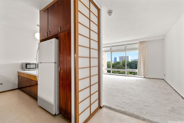 1519 Nuuanu Ave Unit 1044, Honolulu, HI 96817 - kitchen with freestanding refrigerator, light carpet, stainless steel microwave, and light countertops