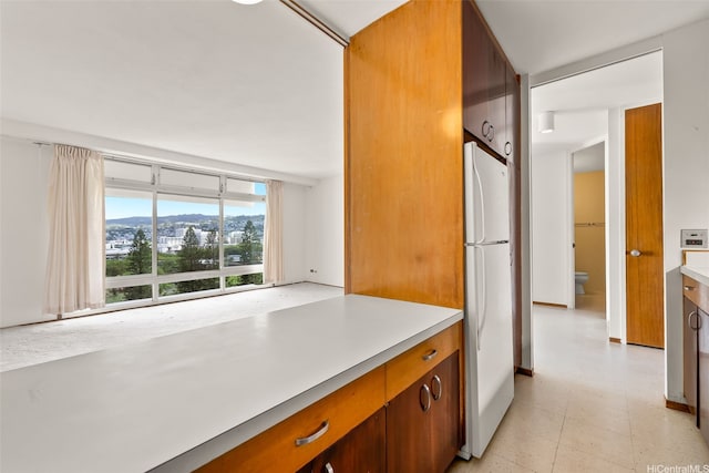 1519 Nuuanu Ave Unit 1044, Honolulu, HI 96817 - kitchen with freestanding refrigerator, light countertops, and brown cabinetry
