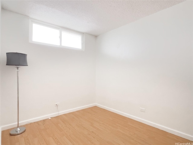 98-099 Uao Pl Unit 3209, Aiea, HI 96701 - below grade area featuring a textured ceiling, light wood-type flooring, and baseboards