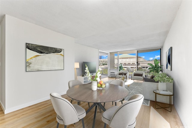 1717 Ala Wai Blvd Unit 701, Honolulu, HI 96815 - dining room featuring a wall of windows, light wood-type flooring, and baseboards