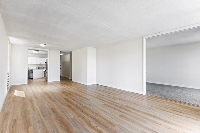 1717 Ala Wai Blvd Unit 701, Honolulu, HI 96815 - unfurnished living room with light wood-type flooring, baseboards, and a textured ceiling