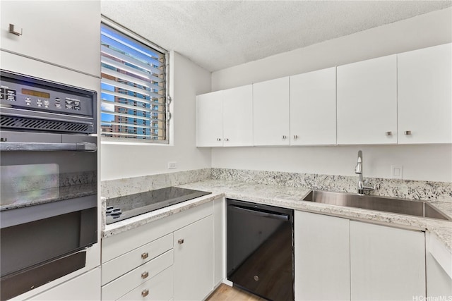 1717 Ala Wai Blvd Unit 701, Honolulu, HI 96815 - kitchen featuring black appliances, a sink, a textured ceiling, white cabinetry, and light countertops
