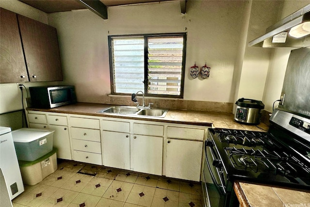 87217 Helelua St Unit 1, Waianae, HI 96792 - kitchen featuring appliances with stainless steel finishes, a sink, under cabinet range hood, light tile patterned flooring, and white cabinetry