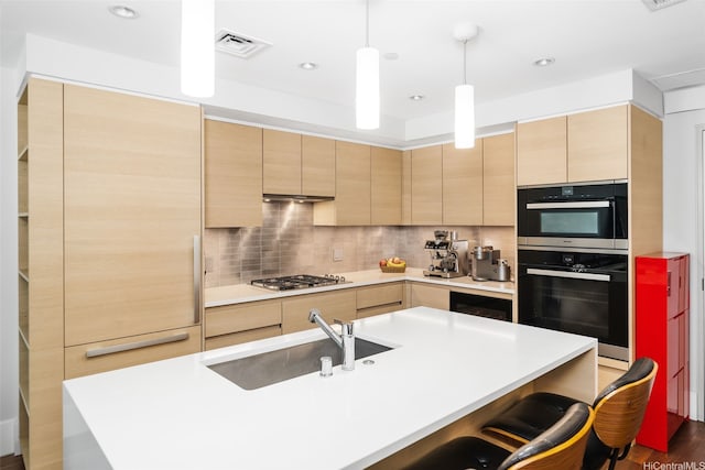 1108 Auahi St Unit 507, Honolulu, HI 96814 - kitchen featuring a sink, light brown cabinets, stainless steel gas cooktop, a kitchen bar, and backsplash