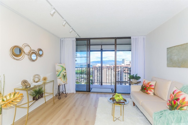 98-500 Koauka Loop Unit 23H, Aiea, HI 96701 - living area featuring expansive windows, wood finished floors, and rail lighting