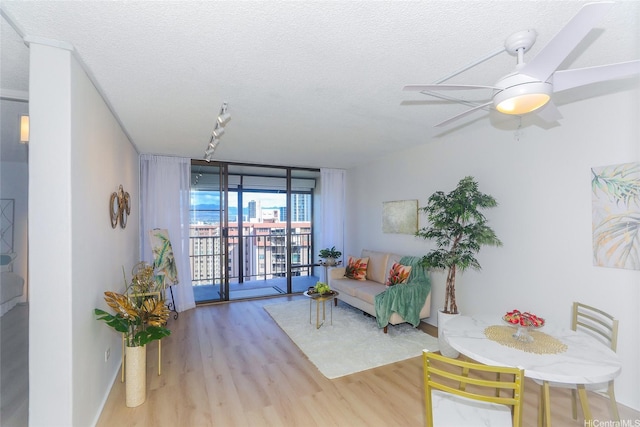 98-500 Koauka Loop Unit 23H, Aiea, HI 96701 - living room featuring wood finished floors, a textured ceiling, a wall of windows, and ceiling fan