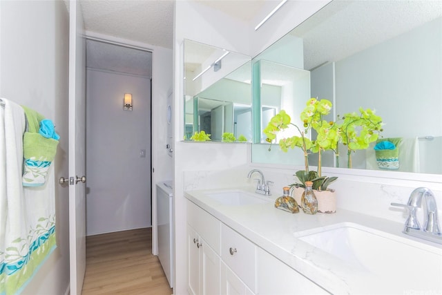 98-500 Koauka Loop Unit 23H, Aiea, HI 96701 - bathroom with double vanity, wood finished floors, independent washer and dryer, and a textured ceiling