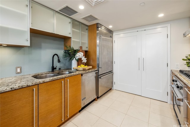1177 Queen St Unit 4306, Honolulu, HI 96814 - kitchen with appliances with stainless steel finishes, light stone countertops, light tile patterned floors, brown cabinetry, and recessed lighting