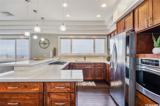 1011-L Alewa Dr, Honolulu, HI 96817 - kitchen featuring appliances with stainless steel finishes, dark wood-style flooring, hanging light fixtures, brown cabinets, and light stone counters