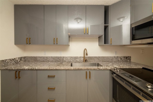 46-232 Kahuhipa St Unit B205, Kaneohe, HI 96744 - kitchen featuring a sink, gray cabinets, stainless steel appliances, and light stone countertops