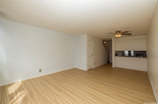 46-232 Kahuhipa St Unit B205, Kaneohe, HI 96744 - unfurnished living room with a textured ceiling, a ceiling fan, light wood finished floors, and a sink