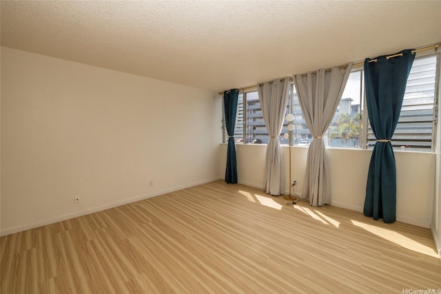 46-232 Kahuhipa St Unit B205, Kaneohe, HI 96744 - spare room with light wood-style flooring, a textured ceiling, and baseboards