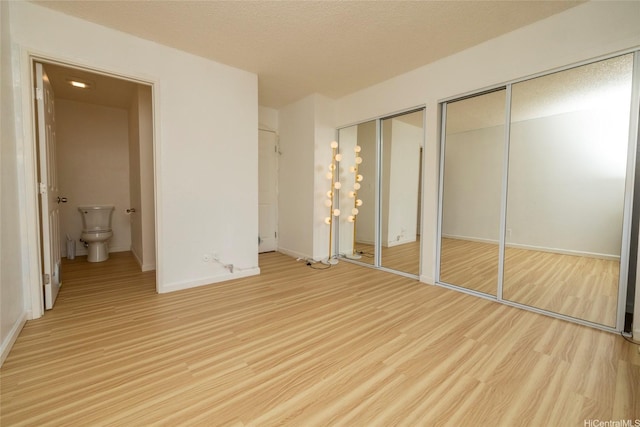 46-232 Kahuhipa St Unit B205, Kaneohe, HI 96744 - unfurnished bedroom with multiple closets, light wood-type flooring, and baseboards