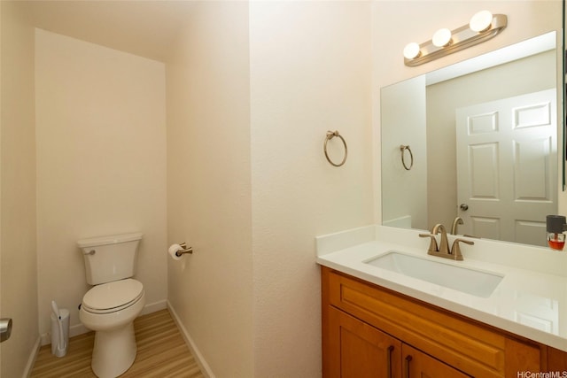 46-232 Kahuhipa St Unit B205, Kaneohe, HI 96744 - half bathroom featuring toilet, vanity, wood finished floors, and baseboards