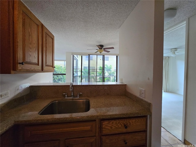 322 Aoloa St Unit 208, Kailua, HI 96734 - kitchen with a sink, a textured ceiling, ceiling fan, brown cabinetry, and stone countertops
