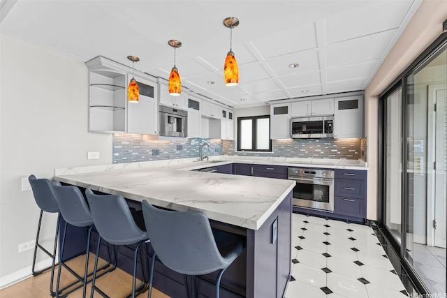 2893 Kalakaua Ave Unit 3, Honolulu, HI 96815 - kitchen featuring appliances with stainless steel finishes, a peninsula, a sink, a kitchen bar, and decorative backsplash