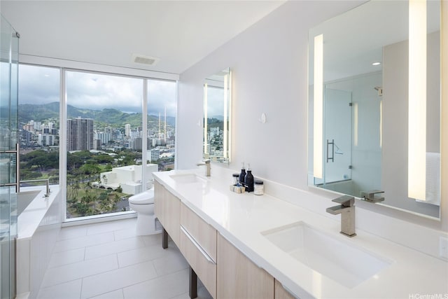 888 Kapiolani Blvd Unit 2703, Honolulu, HI 96813 - bathroom featuring double vanity, tile patterned flooring, a freestanding tub, a mountain view, and expansive windows