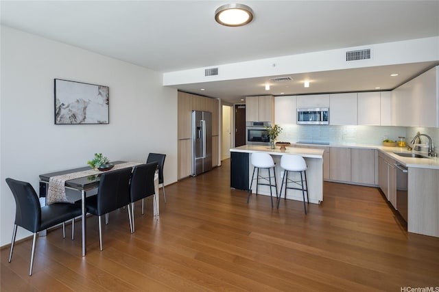 888 Kapiolani Blvd Unit 2703, Honolulu, HI 96813 - kitchen with modern cabinets, stainless steel appliances, a breakfast bar area, light countertops, and backsplash