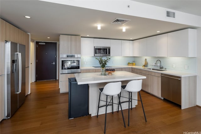 888 Kapiolani Blvd Unit 2703, Honolulu, HI 96813 - kitchen featuring stainless steel appliances, a kitchen bar, dark wood-style floors, light countertops, and tasteful backsplash