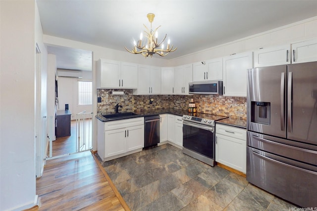 91-652 Kilaha St Unit A4, Ewa Beach, HI 96706 - kitchen featuring appliances with stainless steel finishes, a chandelier, dark countertops, and a wall unit AC