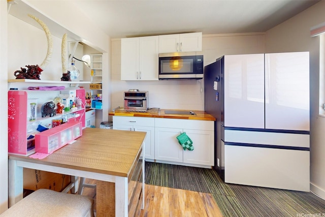 91-652 Kilaha St Unit A4, Ewa Beach, HI 96706 - kitchen with stainless steel microwave, white cabinets, freestanding refrigerator, and butcher block counters