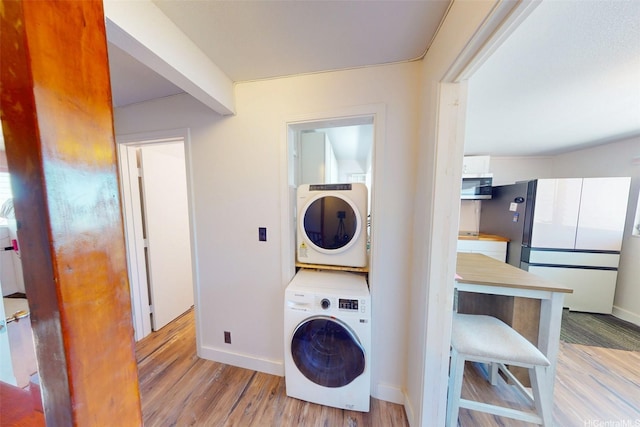 91-652 Kilaha St Unit A4, Ewa Beach, HI 96706 - laundry room with stacked washing machine and dryer and wood finished floors