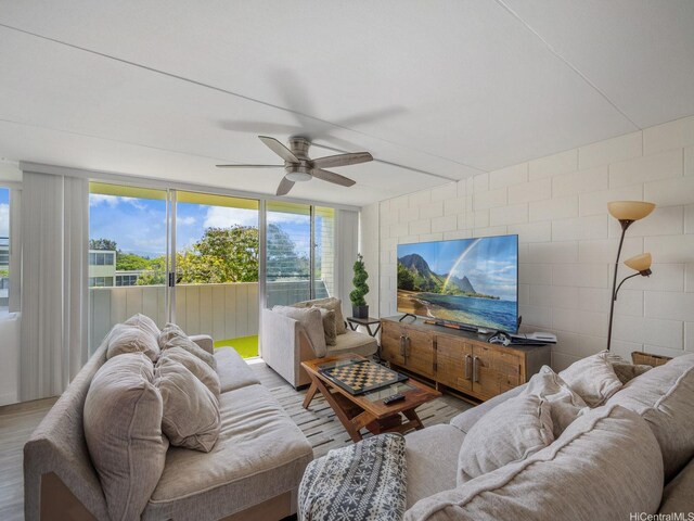 95-31 Kuahelani Ave Unit 439, Mililani, HI 96789 - living room featuring ceiling fan, wood finished floors, and concrete block wall