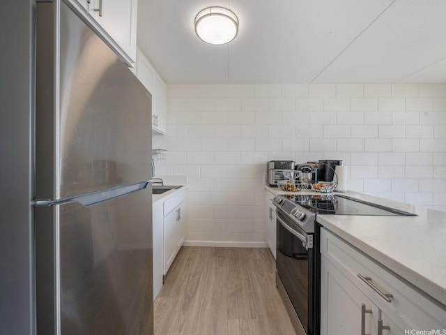 95-31 Kuahelani Ave Unit 439, Mililani, HI 96789 - kitchen featuring stainless steel appliances, light wood-style flooring, white cabinetry, light countertops, and tile walls