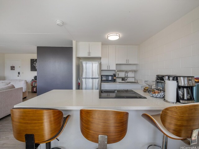 95-31 Kuahelani Ave Unit 439, Mililani, HI 96789 - kitchen featuring freestanding refrigerator, a sink, cooktop, and a kitchen bar