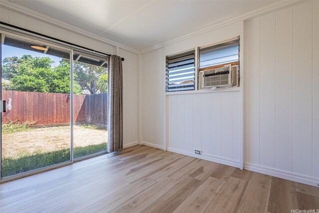 91-517 Pohakupuna Rd, Ewa Beach, HI 96706 - empty room featuring wood finished floors, crown molding, cooling unit, and a decorative wall