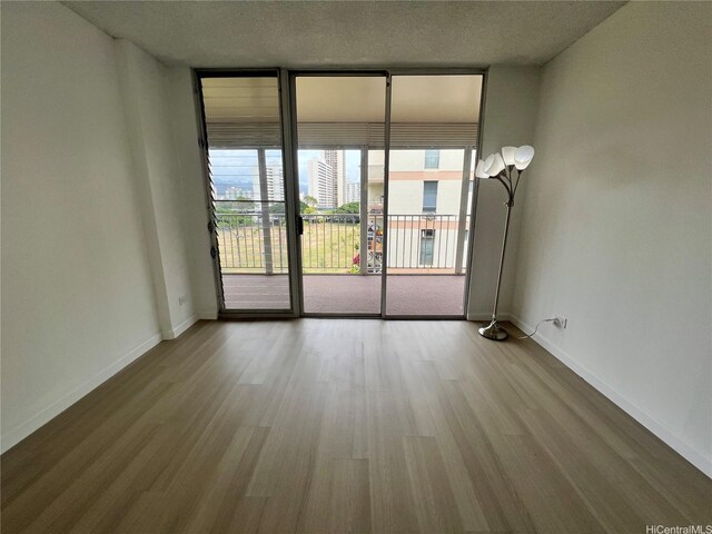 909 Ala Lilikoi St Unit 505, Honolulu, HI 96818 - unfurnished room with wood finished floors and expansive windows