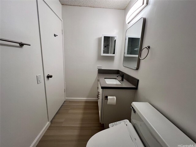 909 Ala Lilikoi St Unit 505, Honolulu, HI 96818 - half bathroom featuring wood finished floors, vanity, and a textured ceiling