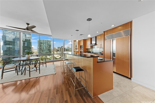 1288 Ala Moana Blvd Unit 21A, Honolulu, HI 96814 - kitchen featuring paneled refrigerator, dark countertops, wall chimney exhaust hood, a breakfast bar, and a view of city
