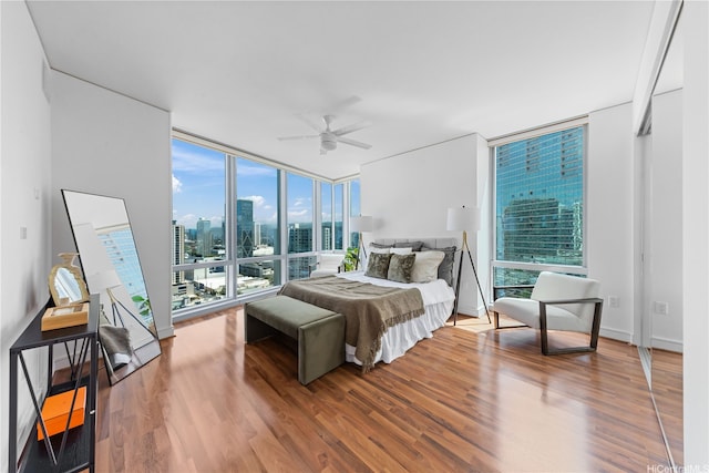 1288 Ala Moana Blvd Unit 21A, Honolulu, HI 96814 - bedroom featuring a wall of windows, wood finished floors, a view of skyline, and a ceiling fan