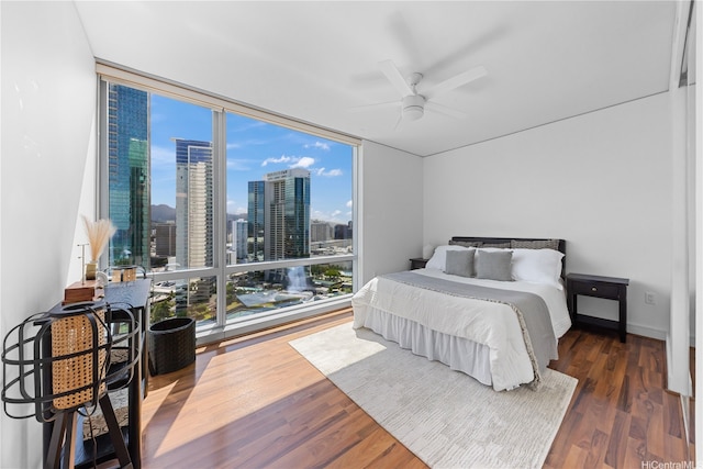 1288 Ala Moana Blvd Unit 21A, Honolulu, HI 96814 - bedroom featuring expansive windows, a skyline view, wood finished floors, and a ceiling fan