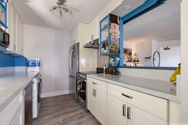 1111 Wilder Ave Unit 14B, Honolulu, HI 96822 - kitchen featuring under cabinet range hood, stainless steel appliances, a textured ceiling, wood finished floors, and white cabinets