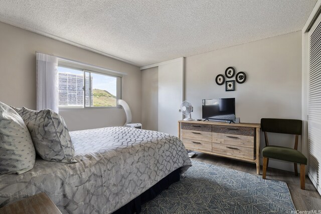 1111 Wilder Ave Unit 14B, Honolulu, HI 96822 - bedroom featuring dark wood-type flooring and a textured ceiling