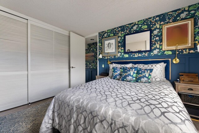 1111 Wilder Ave Unit 14B, Honolulu, HI 96822 - bedroom with wallpapered walls, wood finished floors, and a textured ceiling