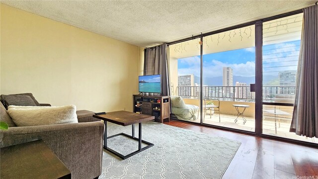 2121 Ala Wai Blvd Unit 1603, Honolulu, HI 96815 - living area featuring expansive windows, wood finished floors, and a textured ceiling