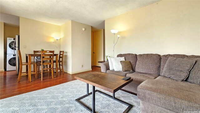 2121 Ala Wai Blvd Unit 1603, Honolulu, HI 96815 - living area featuring estacked washer and dryer, wood finished floors, and baseboards