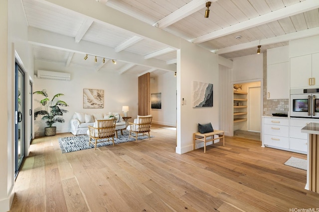 114 Kaelepulu Dr, Kailua, HI 96734 - living room featuring a wall mounted air conditioner, beamed ceiling, light wood-style flooring, and baseboards