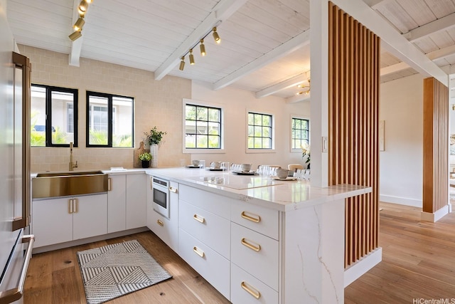 114 Kaelepulu Dr, Kailua, HI 96734 - kitchen with track lighting, a sink, a peninsula, high end refrigerator, and white cabinets