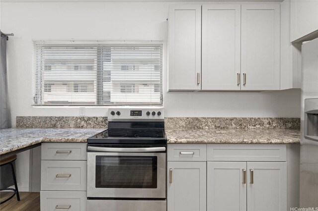 1447 Kewalo St Unit 101, Honolulu, HI 96822 - kitchen with stainless steel range with electric cooktop, healthy amount of natural light, white cabinets, and light stone countertops
