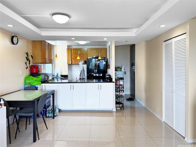 5210 Likini St Unit 810, Honolulu, HI 96818 - kitchen featuring black refrigerator with ice dispenser, a raised ceiling, dark countertops, a peninsula, and recessed lighting