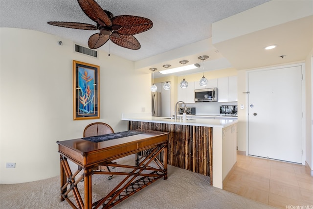 583 Kamoku St Unit Dh2303, Honolulu, HI 96826 - kitchen featuring appliances with stainless steel finishes, a peninsula, white cabinetry, ceiling fan, and hanging light fixtures