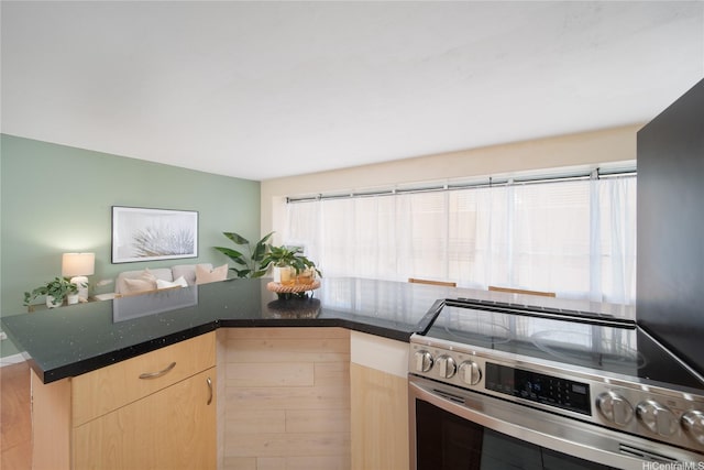 2525 Date St Unit 405, Honolulu, HI 96826 - kitchen with stainless steel range with electric cooktop, light brown cabinets, dark stone counters, and open floor plan