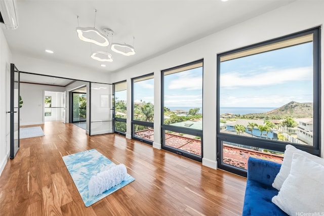 123 Waihili Pl, Honolulu, HI 96825 - unfurnished living room with wood finished floors, a wall mounted AC, a chandelier, and recessed lighting